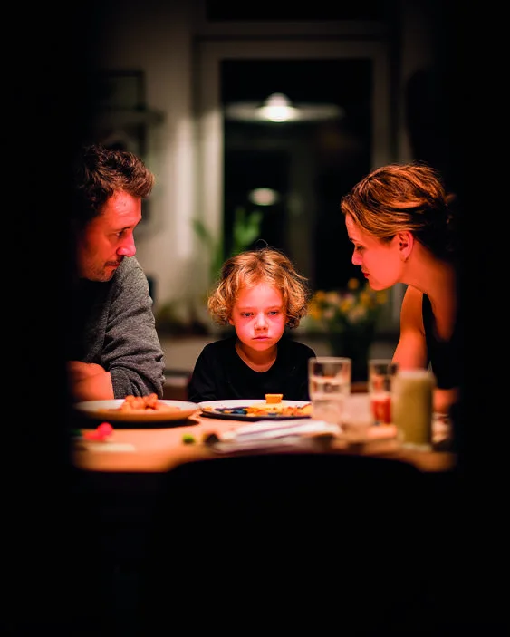 Eine Familie sitzt gemeinsam am Tisch.