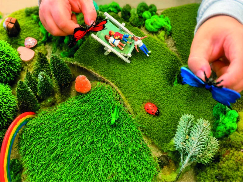 Gestaltete Spiellandschaft mit Figuren, Tieren und Naturmaterialien.